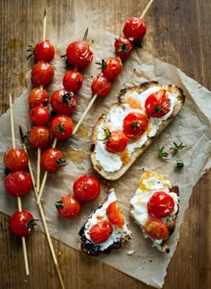 toasted bread with cherry tomatoes and goat cheese on top, along with toothpicks