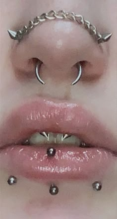 a woman's lips with piercings on them