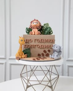 there is a cake with animals on it and the words in russian are made out of fondant