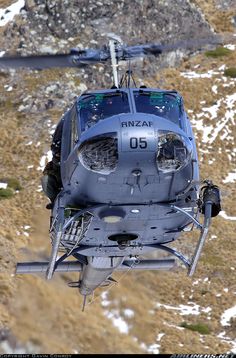 the helicopter is flying high in the sky above the snow - covered mountain side area