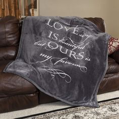 a couch with a blanket on it that says love is beautiful and ours is my favorite