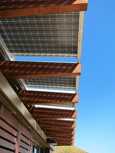 the side of a building with wooden slats on it's sides and a blue sky in the background