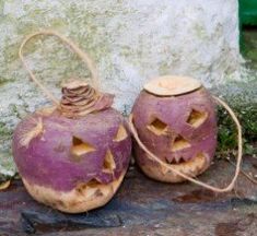 two purple pumpkins with faces carved into them