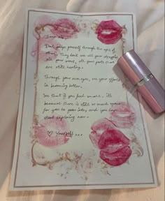 a note with lipstick on top of it next to a bottle of lip glosses