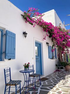 an alleyway with blue shutters and flowers growing on the side of it's building