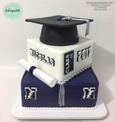 a graduation cake with a mortar and diploma cap on top, sitting on a white plate