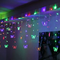 a room filled with lots of colorful lights and butterflies hanging from the ceiling above it