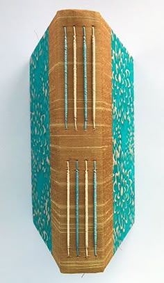 a wooden box with knitting needles in it on a white surface and a blue background