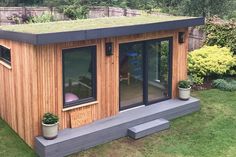 a small wooden building sitting on top of a lush green field