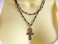 Without a doubt, this necklace is going to gather compliment after compliment for you! The double strand black beaded chains are tiny hematite beads, and the classic Egyptian Ankh has attitude and charm! I have other necklaces in similar styles, both choker length like this as well as longer chains - look for them here in the shop: https://www.etsy.com/shop/ChathamsCrossing/search?search_query=rosary&order=date_desc&view_type=list&ref=shop_search Black Spiritual Chain Necklace, Spiritual Black Chain Necklaces, Spiritual Black Chain Necklace, Black Ankh Necklace In Metal, Ankh Shaped Black Metal Necklace, Egyptian Ankh, Ankh Necklace, Beaded Cross, Cross Chain