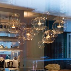 a bunch of bubbles hanging from the ceiling above a table with chairs and other items