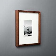 a black and white photo hanging on the wall next to a wooden framed artwork piece