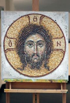 the mosaic portrait of jesus christ is displayed on an easel