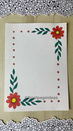 a piece of paper with red flowers and green leaves on it, next to doily