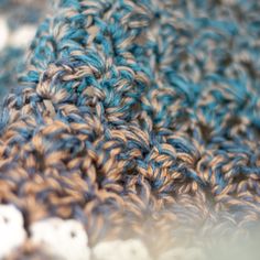 a close up view of a blue and brown crocheted blanket