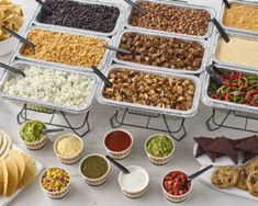 several trays filled with different types of food and dips next to each other