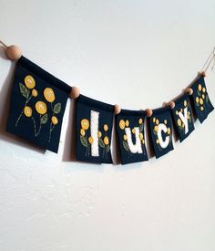 a blue banner with yellow flowers and the word lucky hanging from it's sides