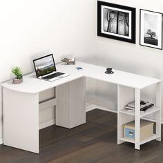 a computer desk with a laptop on it in a corner office space next to two framed pictures