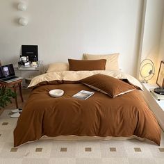 a bed with brown sheets and pillows in a room