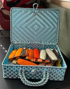 an open blue suitcase sitting on top of a table next to other items in it