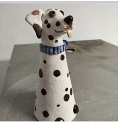 a dalmatian dog figurine sitting on top of a table