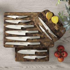 a cutting board with knives and tomatoes on it