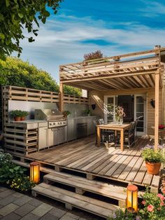 an outdoor kitchen and dining area on a wooden deck with potted plants in the foreground