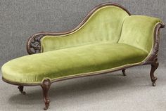 an antique chaise lounge with green velvet upholster