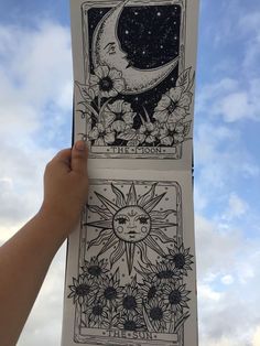 someone is holding up two tarot cards with the sun and moon on them in front of a blue sky