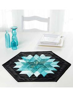 a quilted table mat with a blue and black star design on the center piece