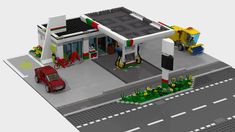 a lego model of a gas station with cars parked in the parking lot next to it