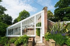 a house with a glass roof surrounded by greenery