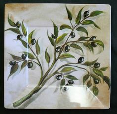 an olive branch with green leaves and black berries is shown in a square frame on a white background