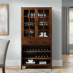 a dining room table and chairs with a wine cabinet in the middle, next to a painting on the wall