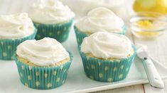 cupcakes with white frosting sitting on a plate