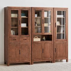 a wooden bookcase with glass doors and drawers