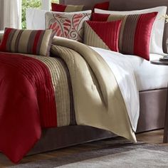 a bed with red and white comforters in a bedroom