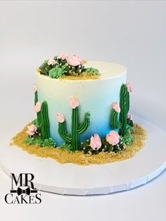 a cake decorated with flowers and cacti on a plate