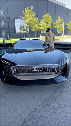 a man standing on top of a black car