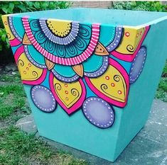 an artisticly painted planter sitting in the grass