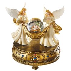 two angel figurines sitting on top of a clock with an inscription in the middle