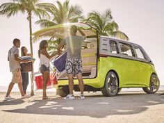 three people standing next to a small car with surfboards in the trunk and luggage