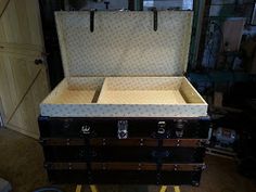 an open trunk sitting on top of a hard wood floor