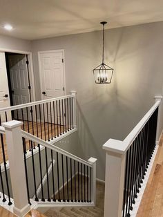 an empty room with white railings and wood flooring