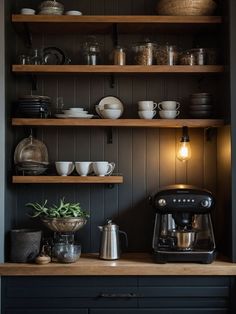 a coffee maker is sitting on the counter in front of shelves with dishes and cups