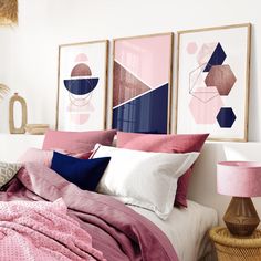 a bedroom with pink and blue decor on the walls, bedding and artwork above it