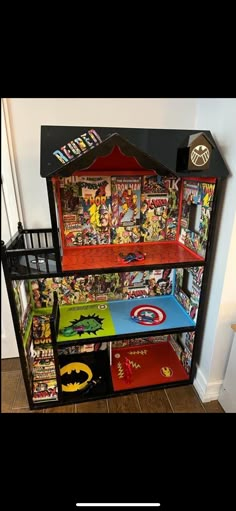 a toy display case with batman comics on the top and bottom shelves, in front of a white wall