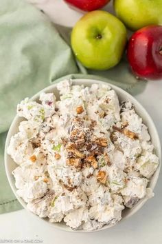 a white bowl filled with food next to apples