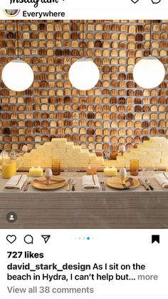 an image of a table with food on it and candles in front of the wall