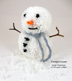 a knitted snowman is standing in the snow